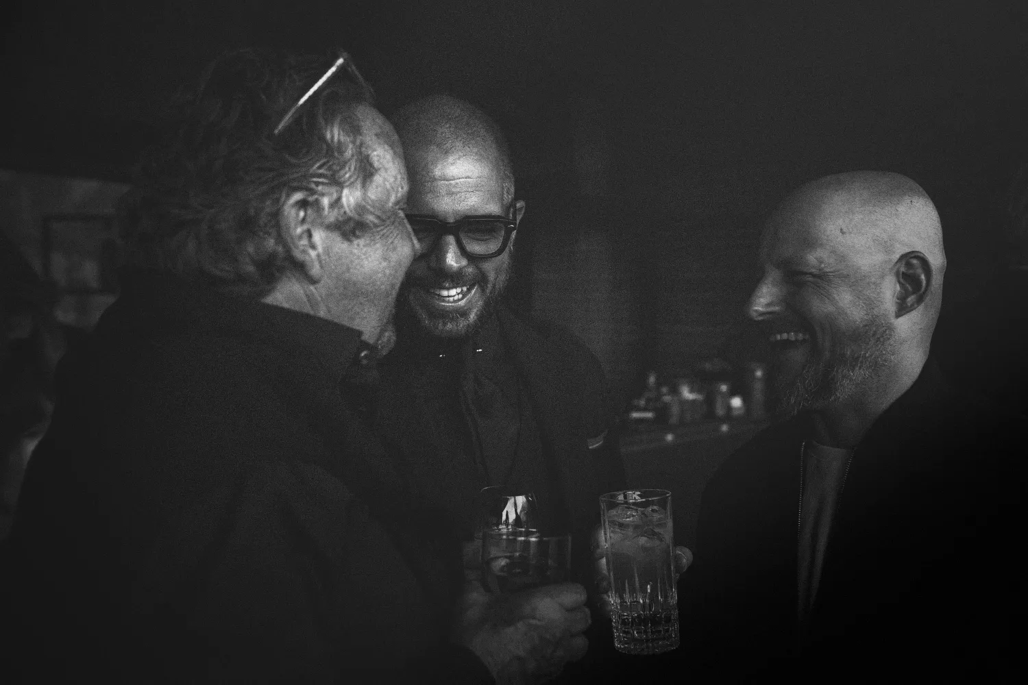 Freunde lachen und stossen an der Bar an