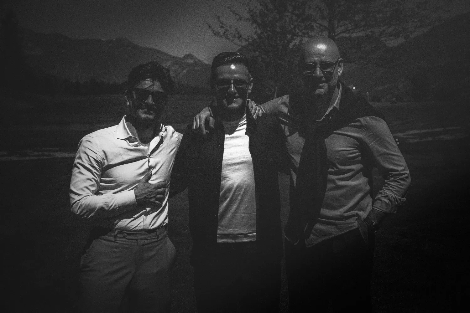 Drei Freunde im Abendlicht vor Bergpanorama