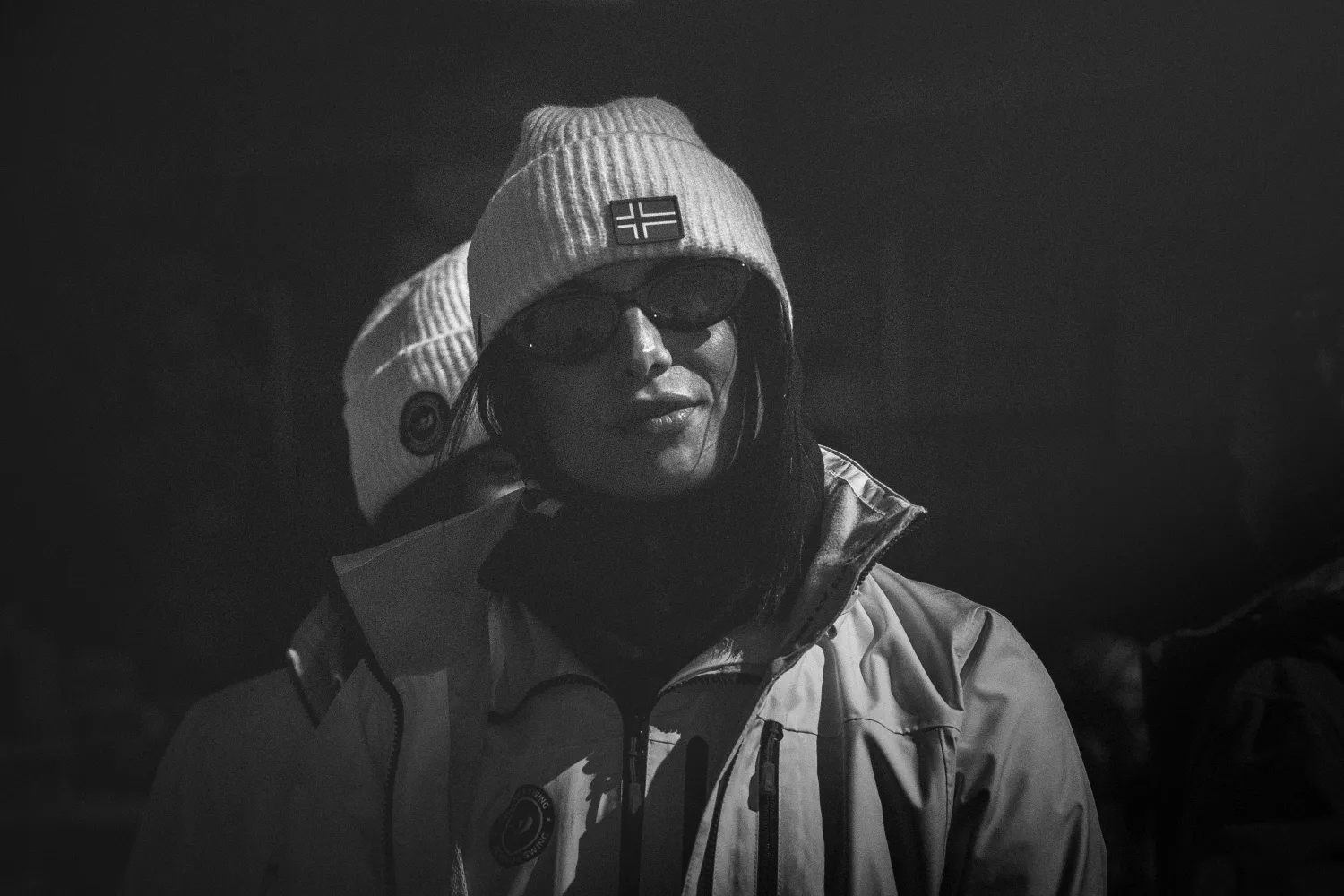 Gast mit Beanie und Sonnenbrille im Schneetreiben